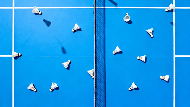 蓝色羽毛球场上的羽毛球散落