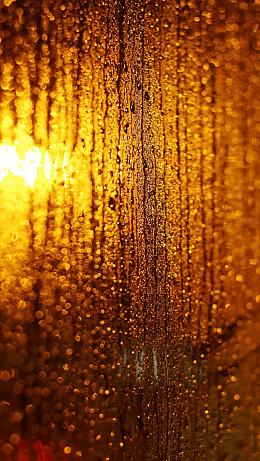 玻璃窗雨珠黄色灯光
