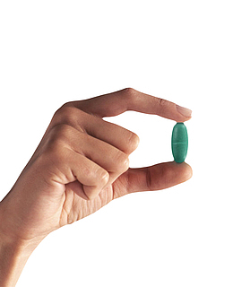 青色治愈手捏着的西药片实物