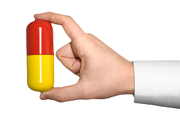 红黄色治愈加大手捏着的西药片实