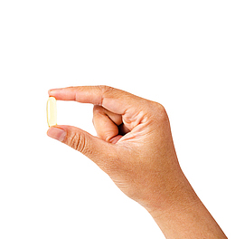 淡黄色治愈手捏着的西药片实物