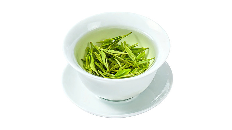 白瓷杯中泡着的绿茶图片