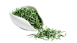 白瓷碗中盛放的绿色茶叶