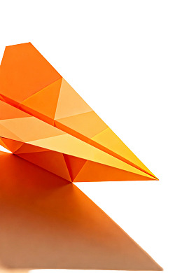 橙色折纸飞机的几何光影