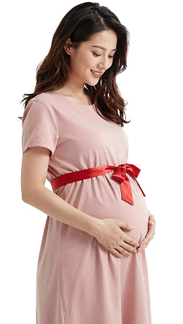 孕妇身着粉色系带连衣裙