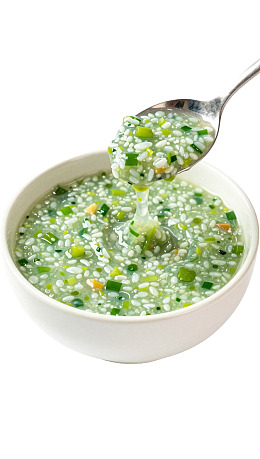 青葱粥盛于白碗勺舀图片