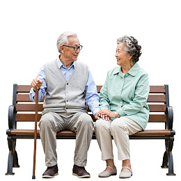 老年夫妇手牵手坐在长椅上