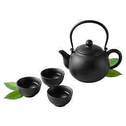 黑色茶壶与茶杯配绿叶