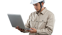 戴安全帽男子使用笔记本电脑