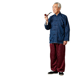 身着传统服饰的老年男子手持烟斗