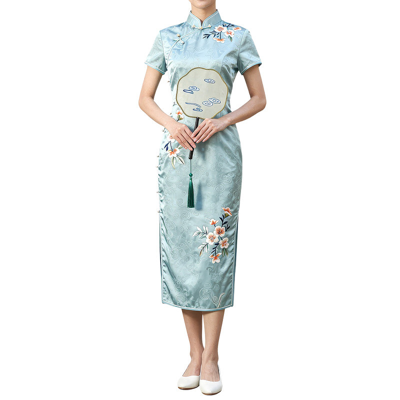 女子身着绣花旗袍手持团扇
