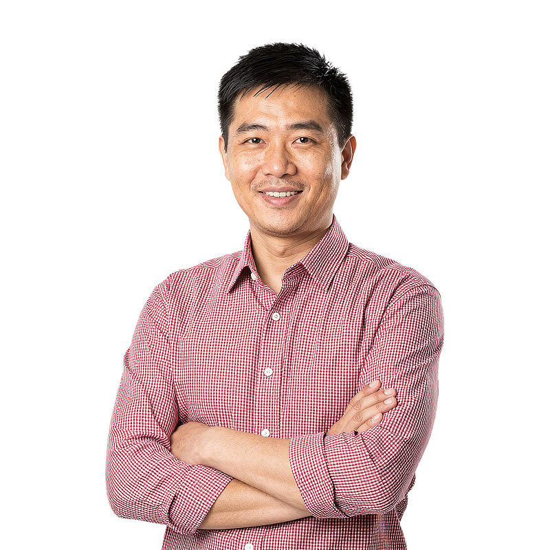 男子穿格子衬衫双臂交叉微笑